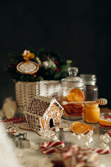 Close-up photo of decorating the Christmas table with gingerbread decorated with icing and citrus fruits on a dark background