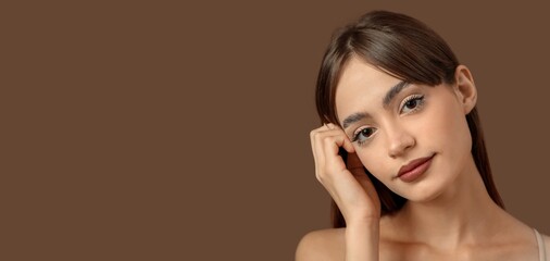 Young woman with beautiful eyebrows on brown background with space for text