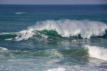 Big waves at Nazarè beach in Portugal, photographs of surfers having fun in the Atlantic Ocean