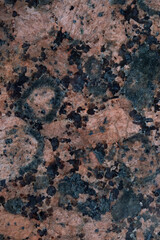 Close-up of a salmon-red, brown and black polished granite stone. Granite pattern vertical backround image.