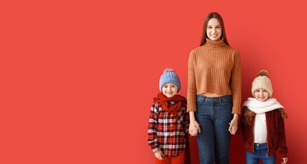Happy family in winter clothes on red background with space for text
