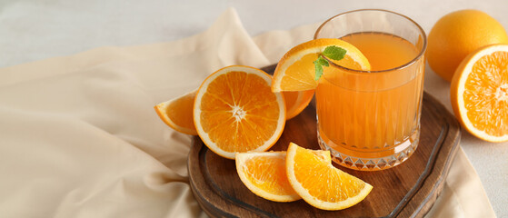 Glass of fresh orange juice with mint and cut fruits on white background