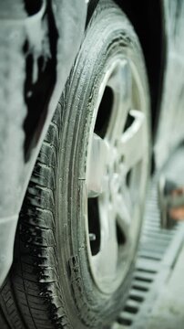 Washing a car wheel with a brush by hand