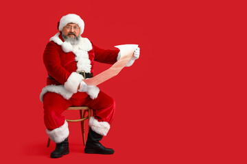 Santa Claus reading letter on red background