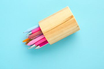 Fototapeta premium Wooden holder with different pens on blue background