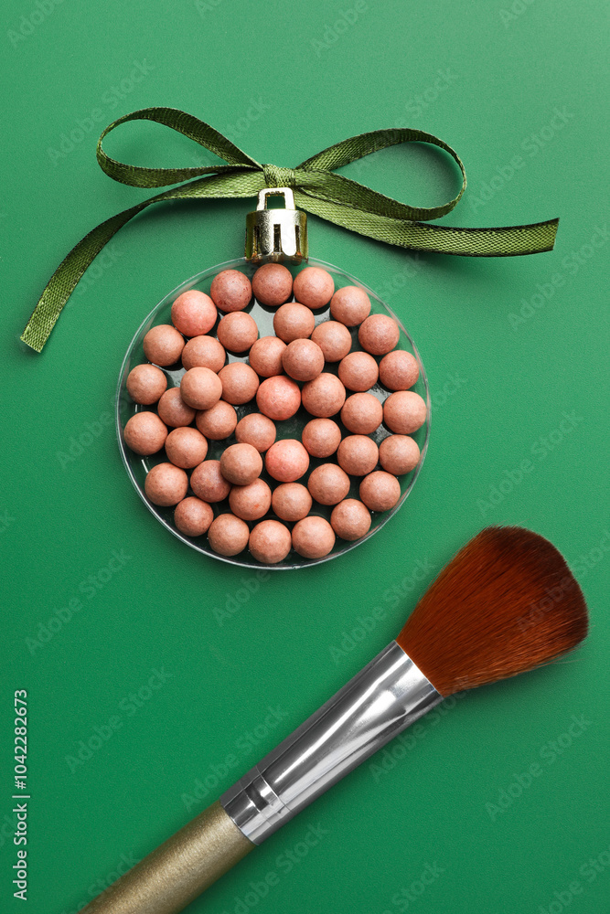 Poster Christmas ball made of cosmetic product, bow and makeup brush on green background, flat lay