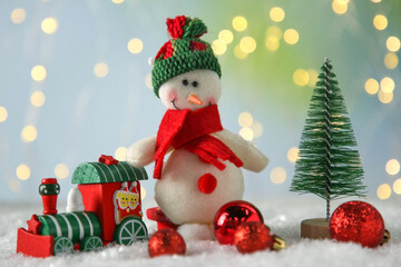 Cute decorative snowman and other Christmas decor on artificial snow
