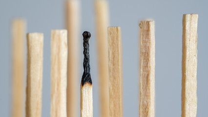 A symbolic representation of a depression of exhaustion, also known as burn out. A row of fresh matches, one has burned down. Concept of overload in the family, company, team or work etc.