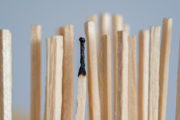 A symbolic representation of a depression of exhaustion, also known as burn out. A row of fresh matches, one has burned down. Concept of overload in the family, company, team or work etc.