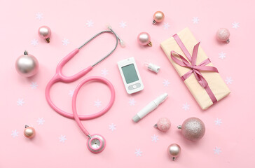 Composition with medical supplies, gift and Christmas decorations on pink background