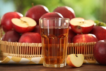 Tasty apple juice in glass and fresh fruits on wooden table outdoors