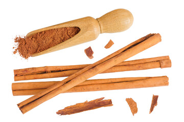 Cinnamon sticks with powder in wooden scoop isolated on white background with full depth of field. Top view. Flat lay.