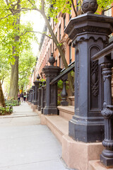Fototapeta premium Classic Brownstone Buildings with Iron Railings in Urban Street 