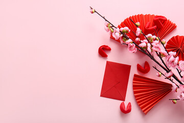 Sakura branch with fortune cookies, red envelope and Chinese symbols on pink background. New Year...