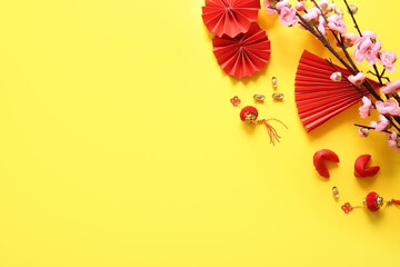Sakura branch with Chinese symbols and fortune cookies on yellow background. New Year celebration
