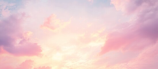 Obraz premium Soft, pastel-colored clouds with a warm glow in the sky.