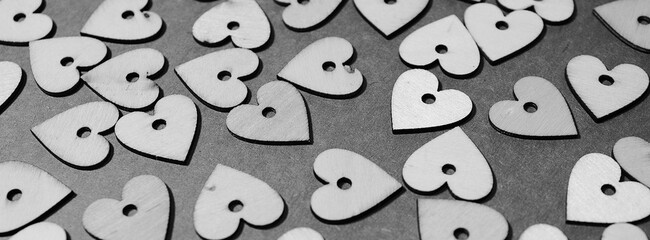 Horizontal Black and White photograph of lots of wooden hearts