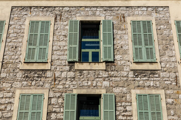 Obraz premium historic stone house with green shutters in the city of Nice, Provence
