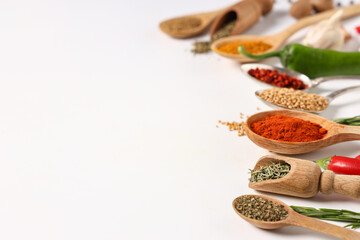 Spoons and scoops with fresh aromatic spices on grey background