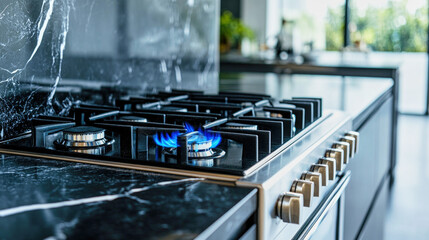 Modern gas stove with blue flames against elegant black marble countertops in a bright luxury kitchen