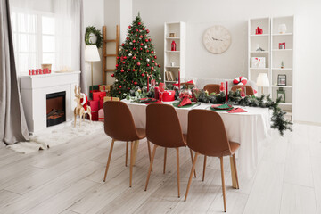 Dining table with setting for Christmas celebration in festive room