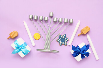 Composition for Hanukkah celebration with menorah, gift boxes and dreidels on lilac background
