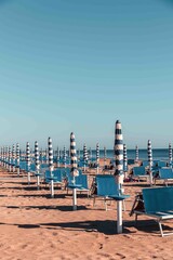 Typical Italian Adriatic Riviera beach near Fano and Marotta, Marche. Rows of blue sunbeds and umbrellas. Vintage vacation atmosphere.