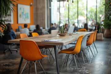 A modern workspace filled with vibrant orange chairs and natural light during a productive afternoon meeting in a bustling environment
