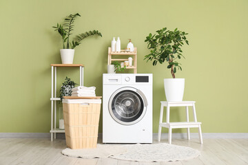 Interior of laundry room with clothes basket, washing machine and houseplants