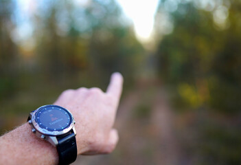 Smartwatch travel. Hiker with sports watch in Expedition. Watch in wild survival. Outdoor, hiking Watch on hand with glove. GPS track Smartwatch. Traveler watch in adventure. Hand Pointing Direction.
