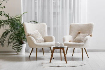 Modern interior of living room with armchairs, cushions and coffee table