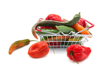 Shopping supermarket basket with fresh organic ripe with assorted colorful peppers whole isolated...