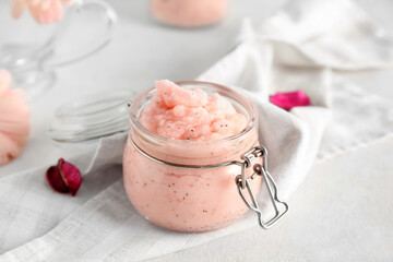 Jar of natural body scrub and napkin on light table