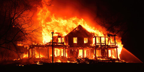 Big luxurious country mansion on fire. Fire in the cottage, flames. Luxury real estate insurance against accidents.