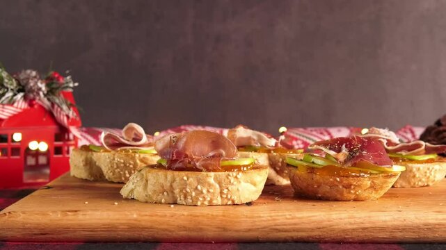 Spanish tapas of Serrano ham, apple and jam, Christmas decoration, blurred background