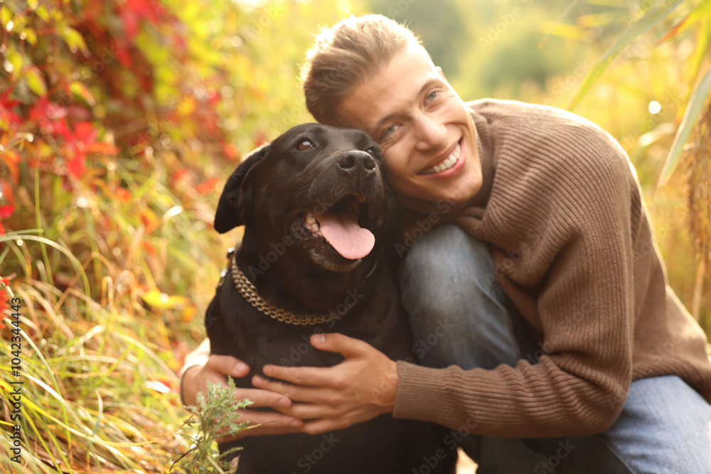 Poster Smiling man hugging cute dog outdoors on autumn day