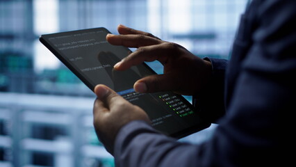 Software developer does yearly checkup using tablet to prolong data center electronics life span. Close up shot of worker in server room monitoring server infrastructure using digital device, camera A