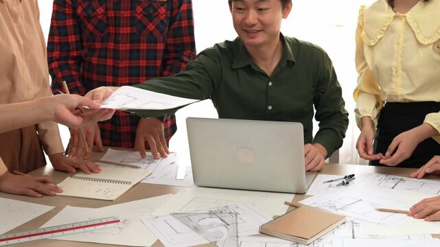 Architect and safety engineer celebrate success design building blueprint project on laptop with architectural document and measurement tool scatter around at modern office. Closeup. Delineation.