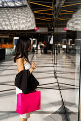 Shopping with brunette wearing white dress girl is looking for bargains in the mall. Holiday...
