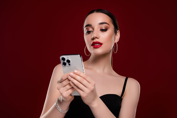 Photo of chic lady using cell smart phone browsing isolated maroon color background