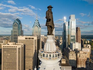 Statue of William Penn on top of  Philadelphia City Hall and the downtown city skyline of...