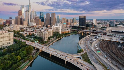 Traffic on the Vine St Expressway crossing the Schuylkill River and the downtown city skyline of Philadelphia at sunset, Pennsylvania, United States.