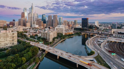 Obraz premium Traffic on the Vine St Expressway crossing the Schuylkill River and the downtown city skyline of Philadelphia at sunset, Pennsylvania, United States.