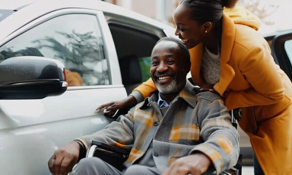 Caregiver assisting a senior man in a wheelchair, providing careful support as he exits the car during an outing. Compassionate moments highlight their connection and shared experience