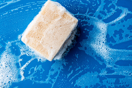 foam sponge for washing dishes lon blue ceramic table with copy space.