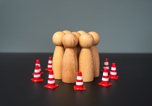 A group of people are surrounded by traffic cones. Limitations and boundaries. Rights and freedoms. Control and supervision, infringement of minorities. Safety