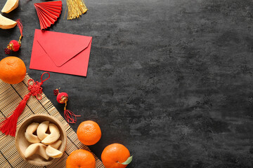 Chinese symbols with red envelope, fortune cookies and mandarins on black grunge background. New...