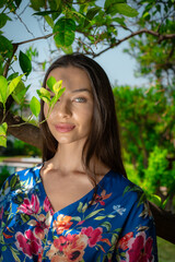 A woman peacefully walking between vibrant lemon trees, enjoying the fresh, natural surroundings, creating a calm and serene atmosphere in a garden.