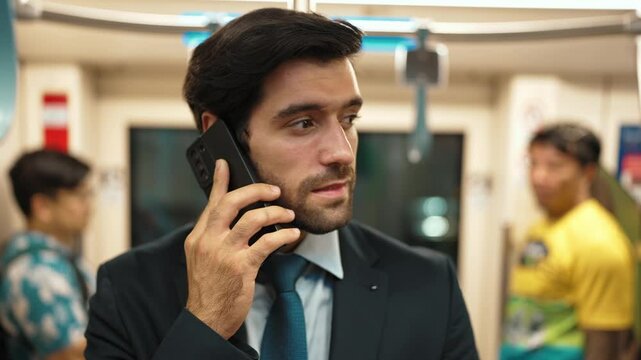 Smart business man phone calling to project manager while standing in train. Professional male leader talking to investor about marketing plan by using phone with blurring background. Exultant.
