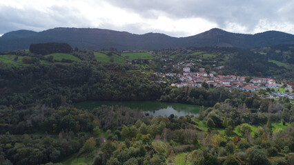 Obraz premium Lago y pueblo en las montañas verdes.